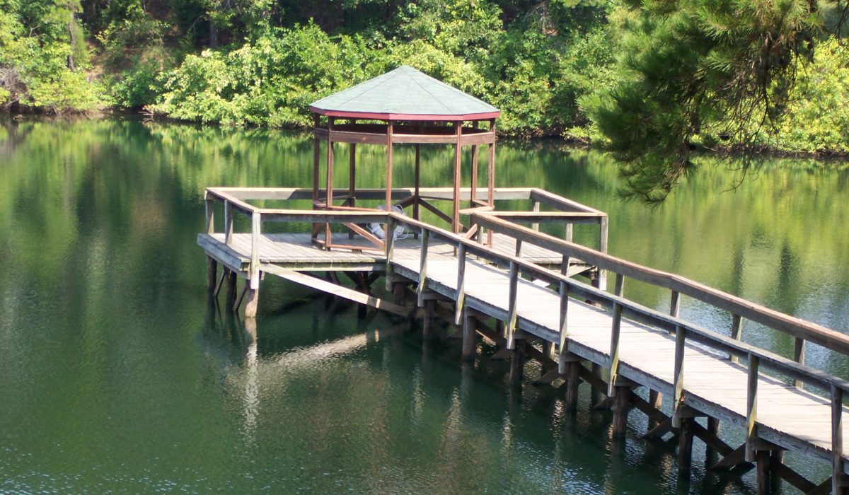 Wooden dock and gazebo overlooking a pond on campus