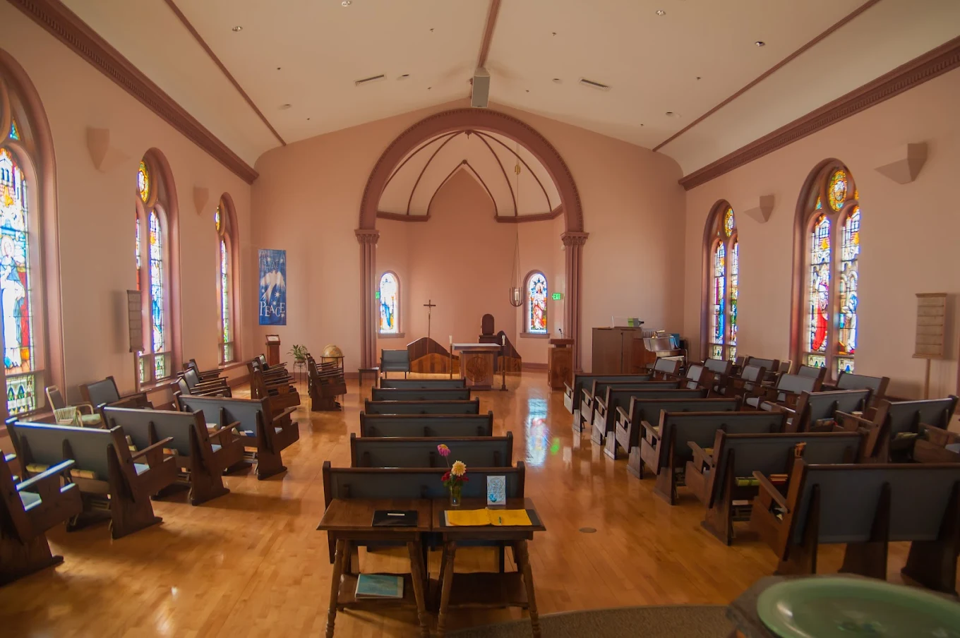 Quiet chapel with wooden pews and stained-glass windows