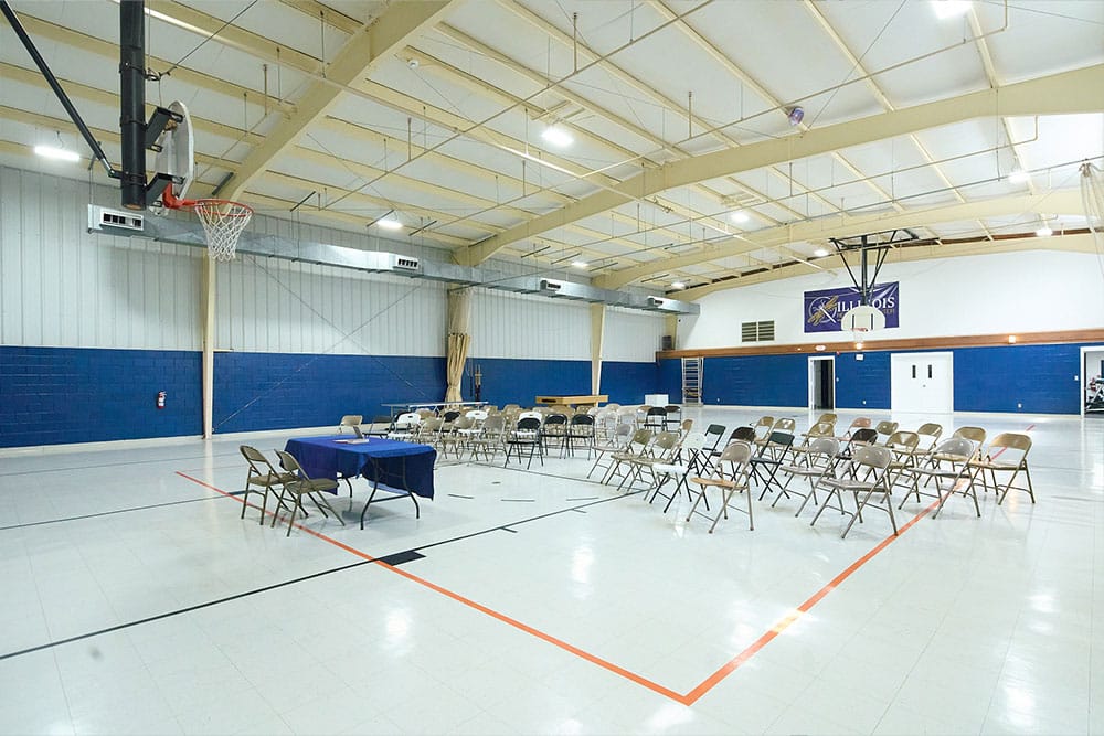 Gymnasium with chairs set up and basketball hoops