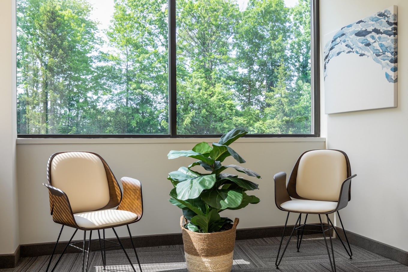 Seating area with two chairs and a large window.