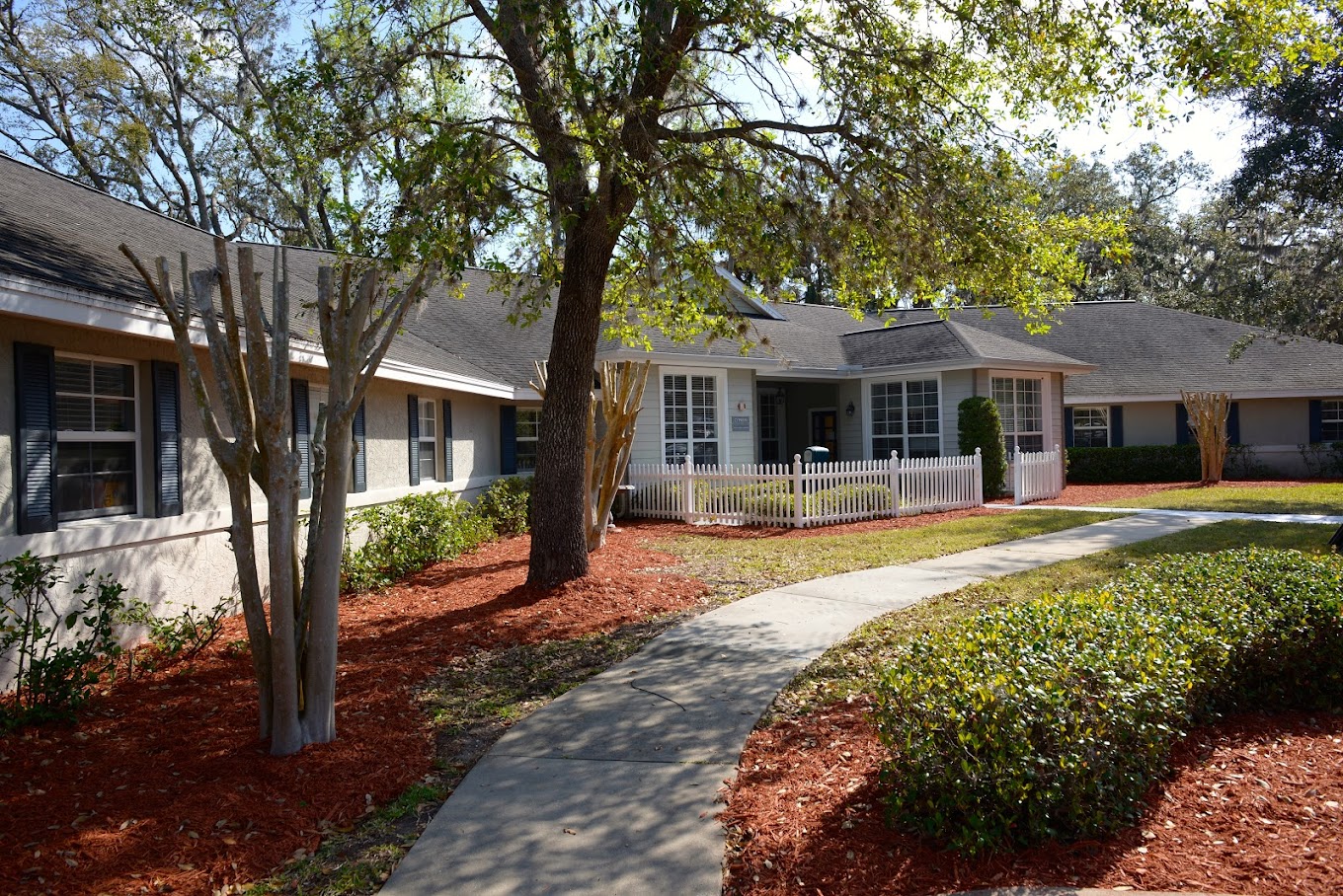 Rehab center with white fence and shaded walkway