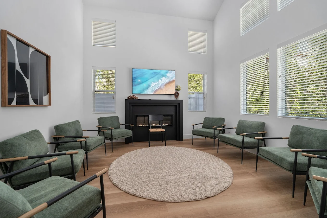 Circle of chairs around fireplace with mounted TV