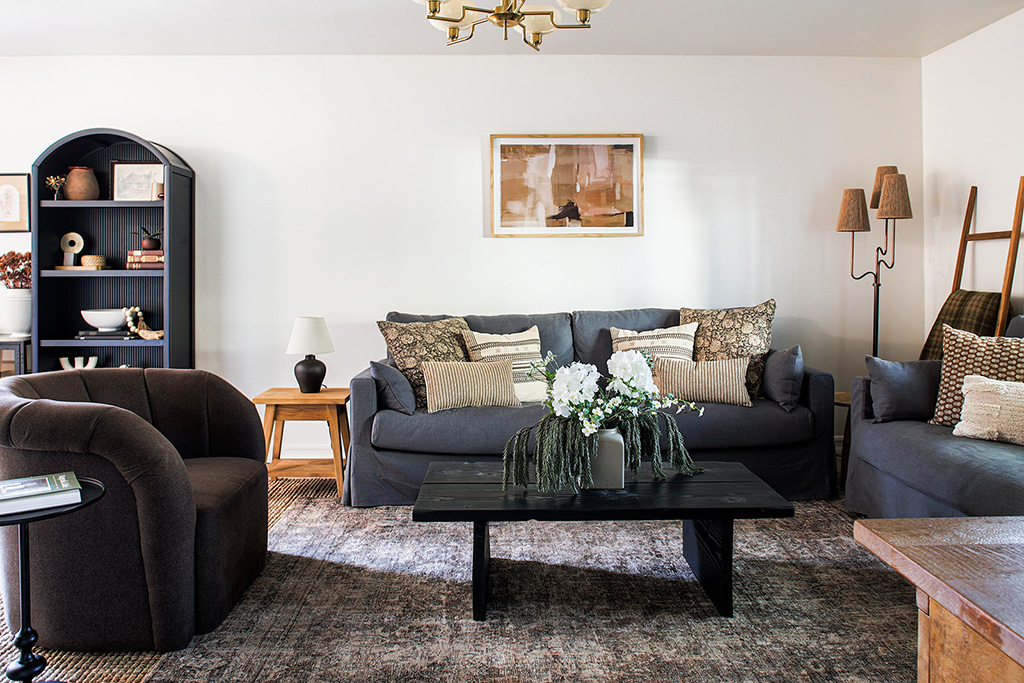 Living room with black sofas, coffee table, and modern décor