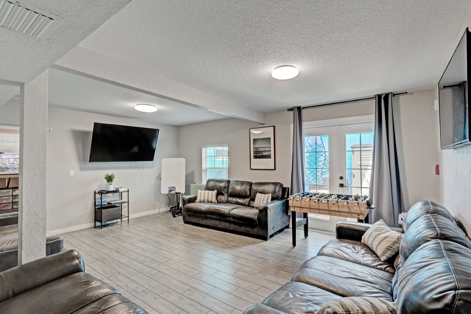Game room with football, couches, and mounted TV