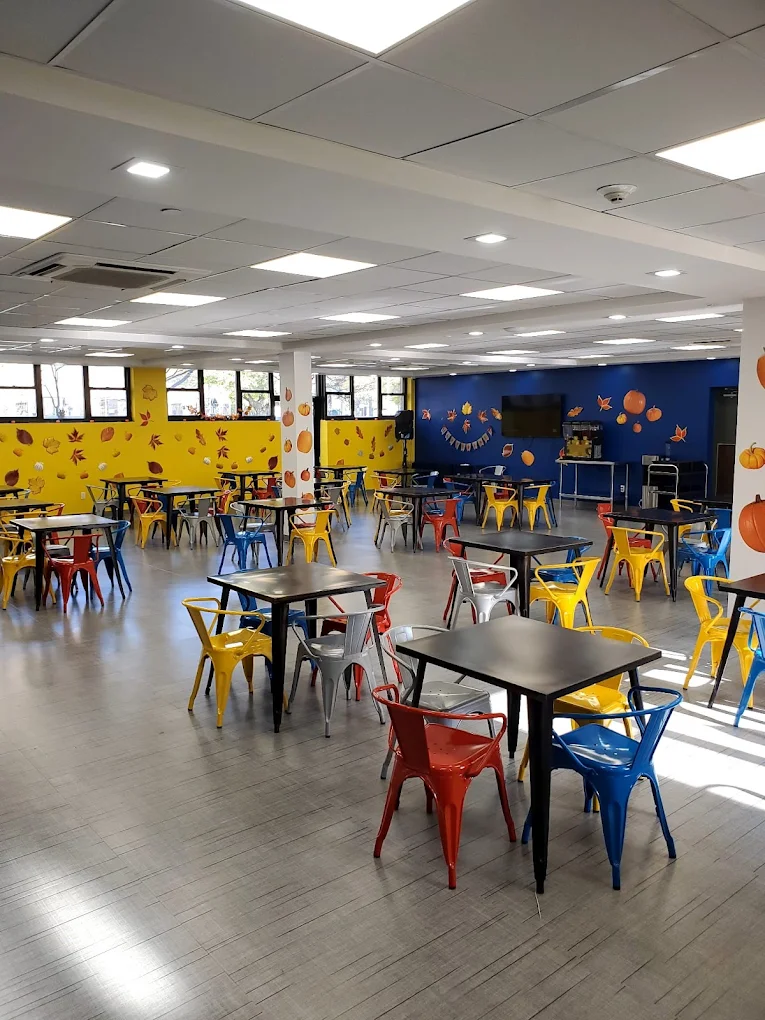 Colorful dining hall with tables, chairs, and wall art