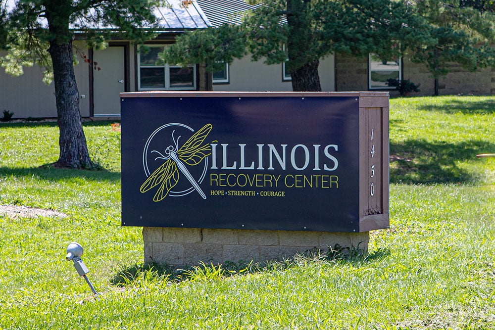 Outdoor sign with dragonfly logo and facility name