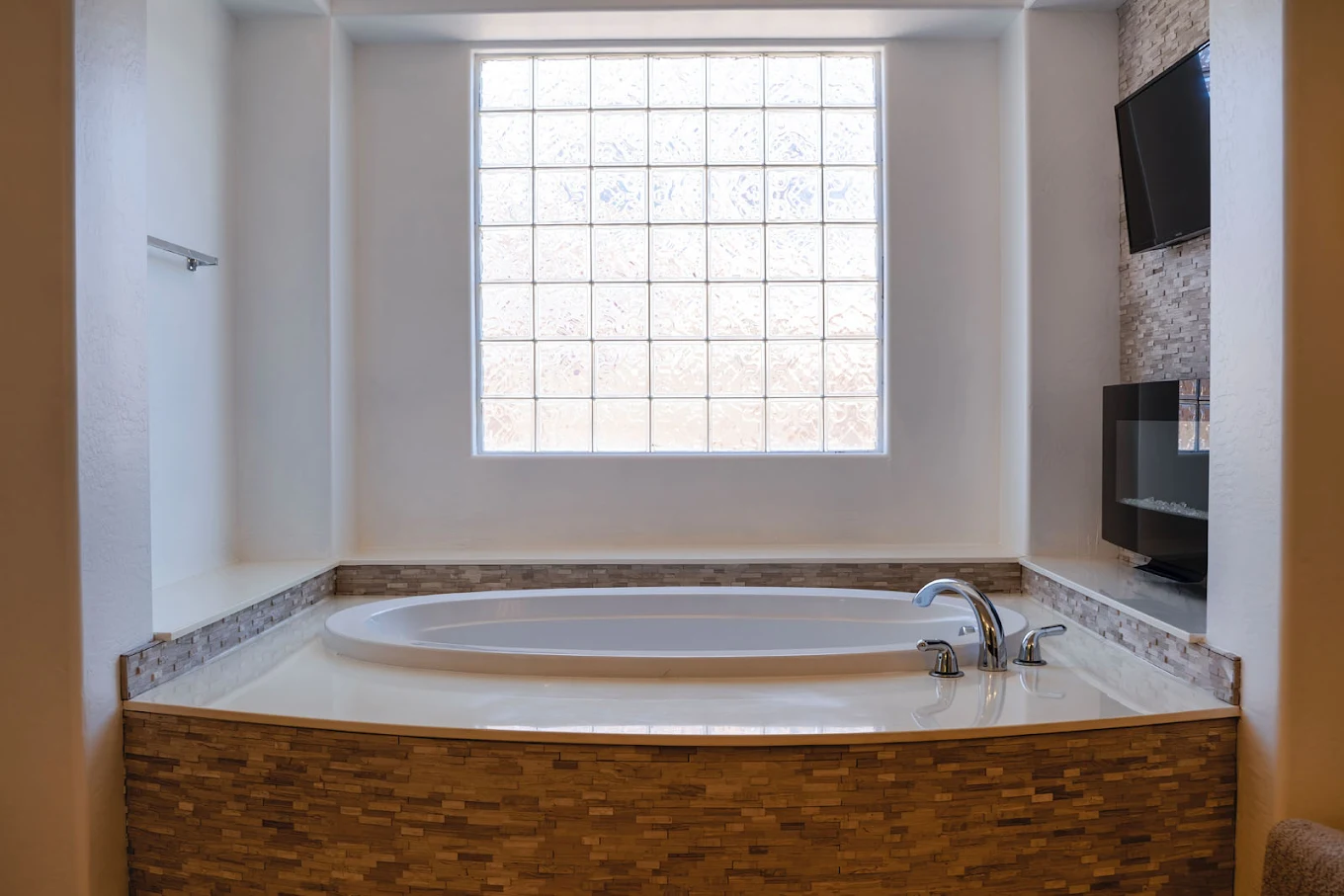 Large soaking tub under window with tiled surround