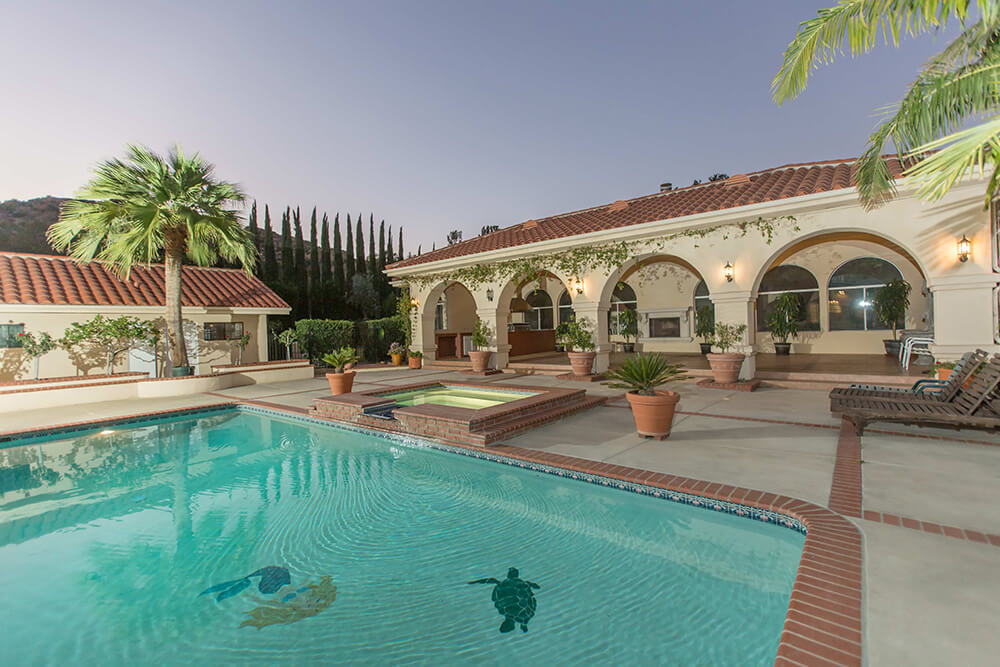 Backyard with a pool, hot tub and seating.