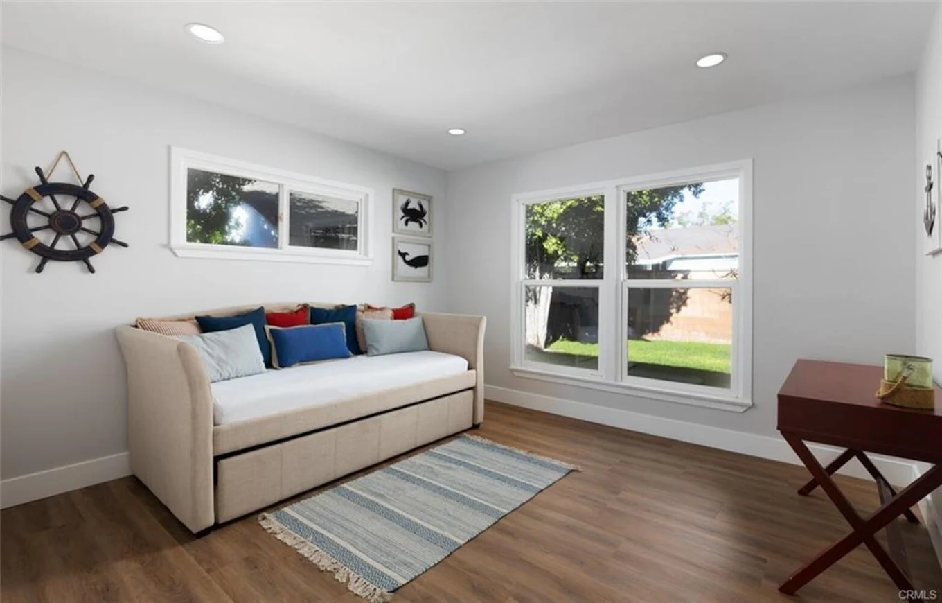 Lounge room with daybed, colorful pillows, and wall decor
