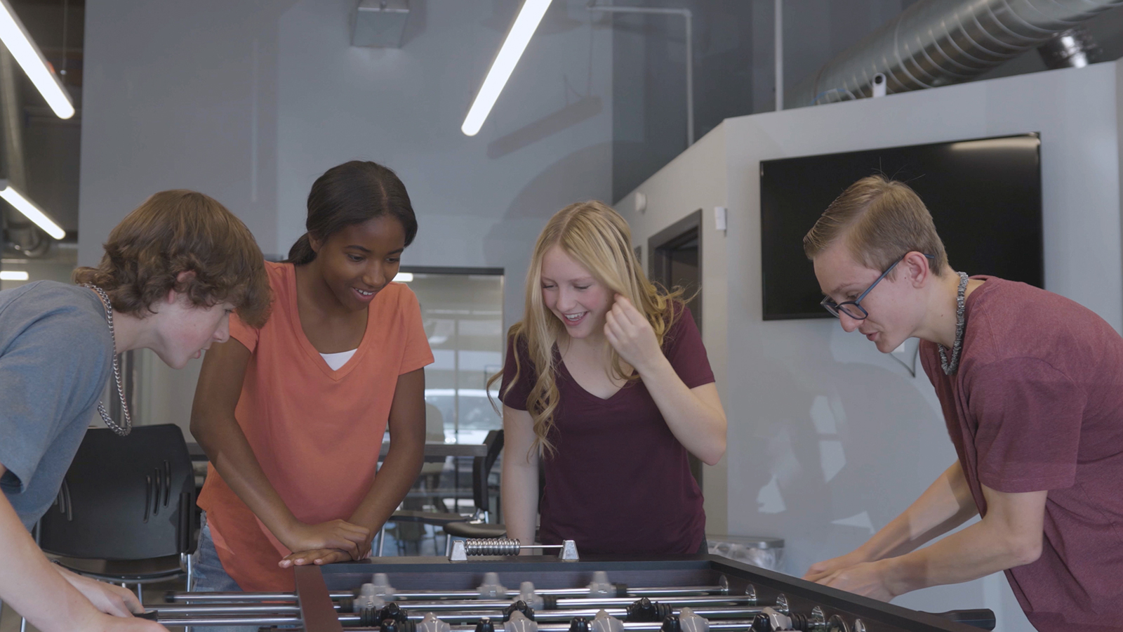 Group of young adults playing foosball.]