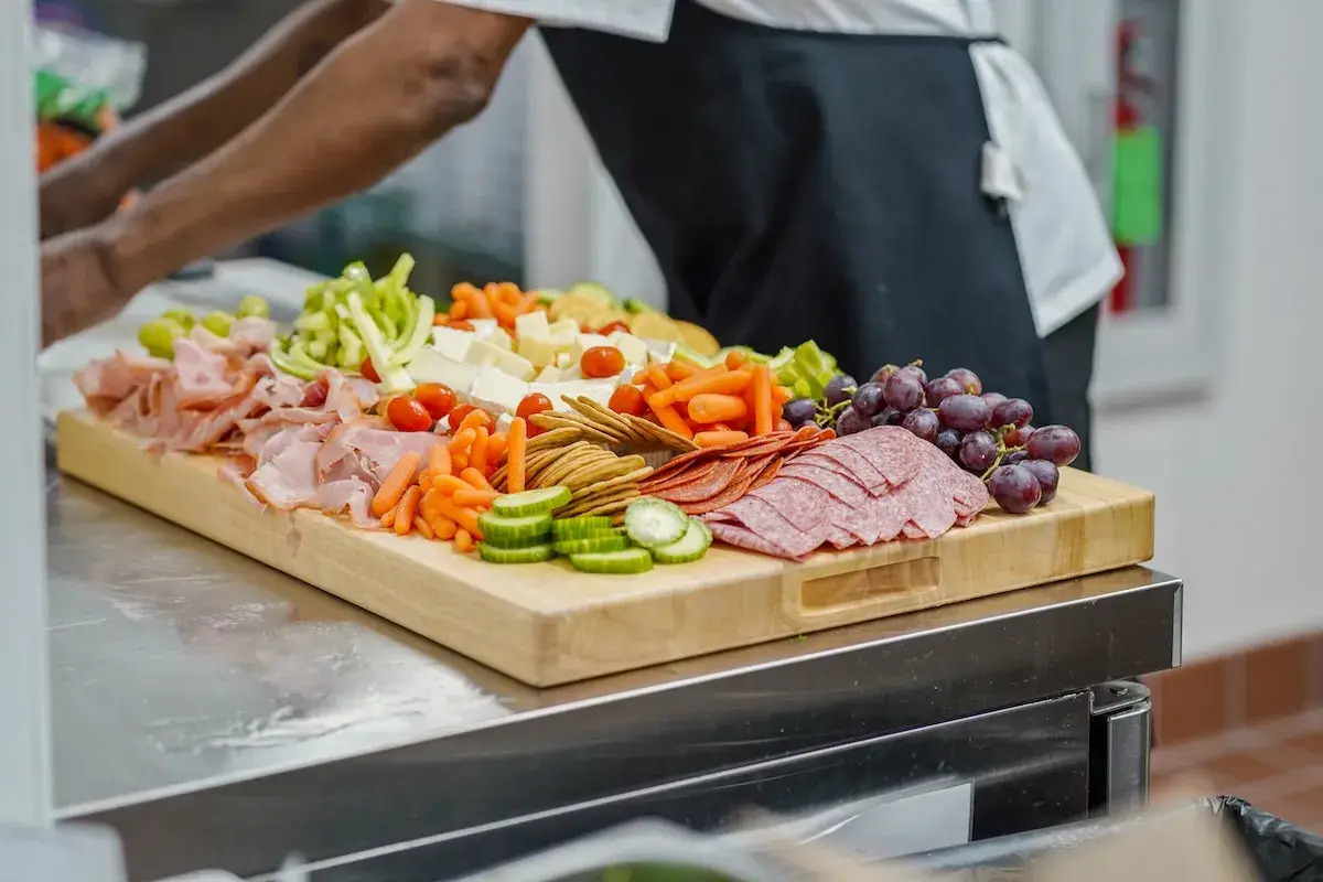 Charcuterie board with meats, cheeses, fruits, and veggies.