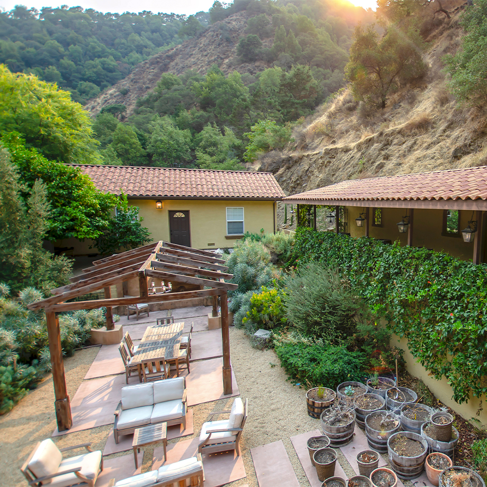 Outdoor seating area with chairs and a pergola.