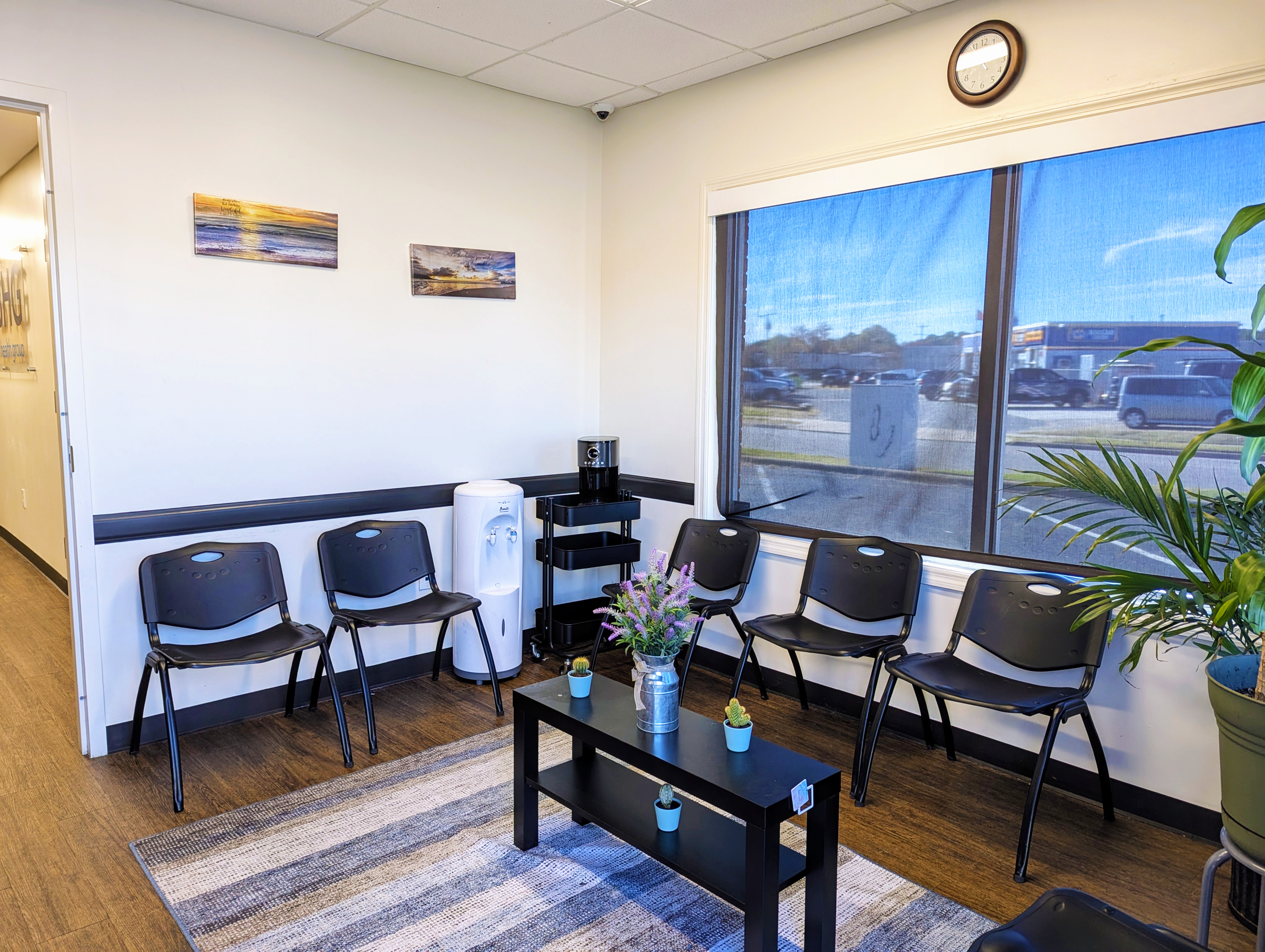 Small lounge with chairs, coffee station, and large window