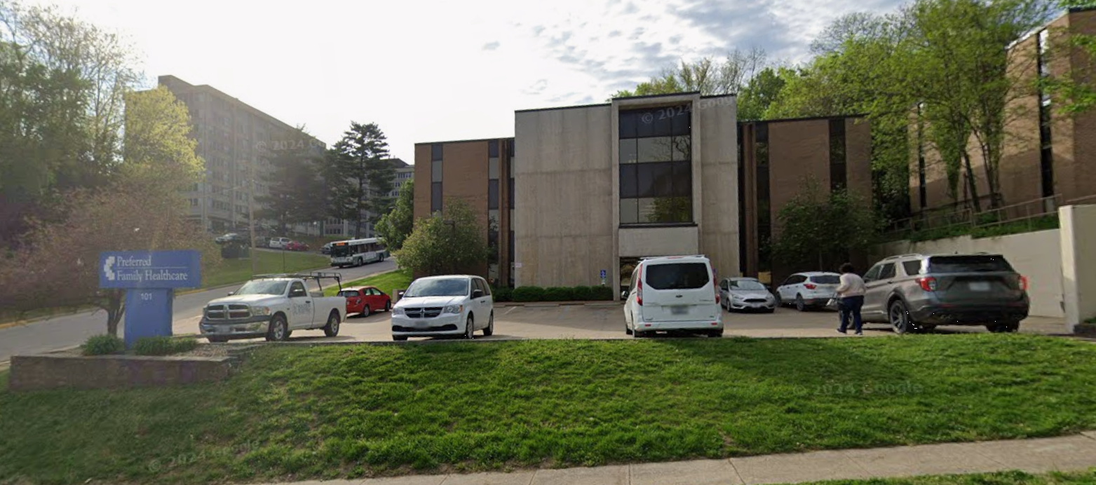 Office building exterior with parking lot and facility sign
