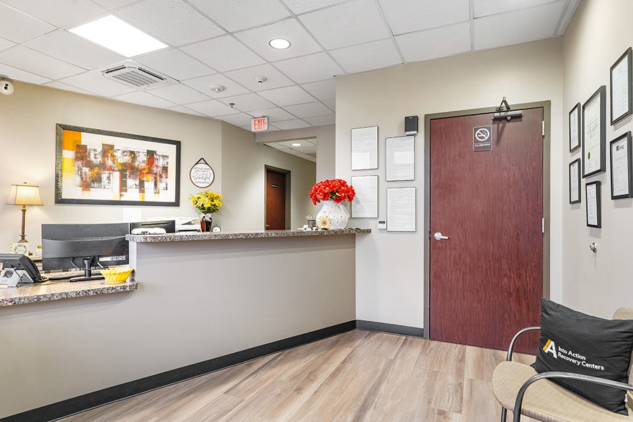Reception area with granite counter, flowers, and framed documents