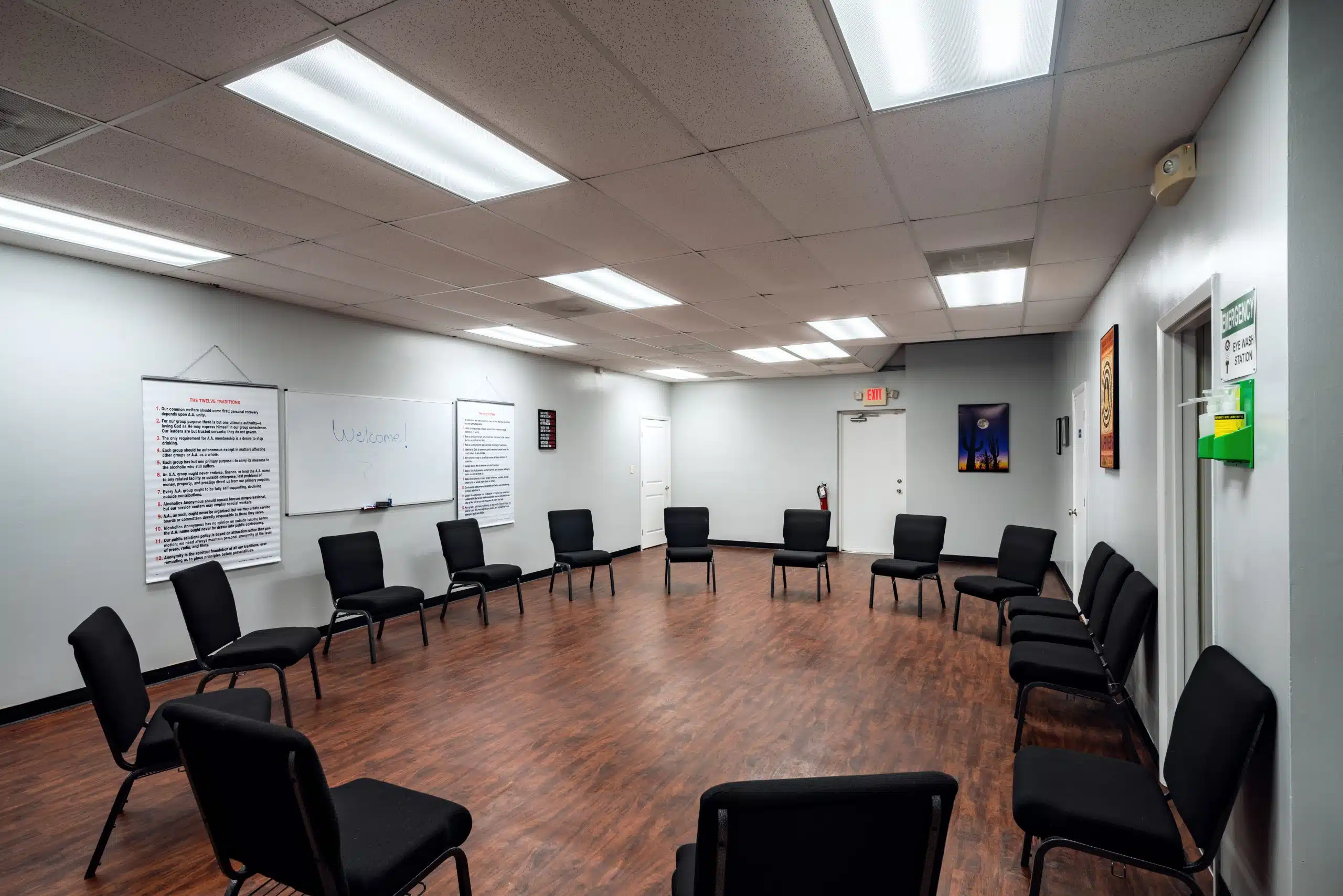 Circle of chairs in a well-lit room with posters on the wall
