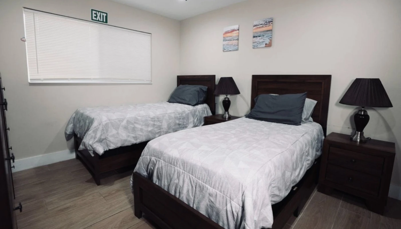 Shared bedroom with twin beds, dark wood furniture, and nightstands.