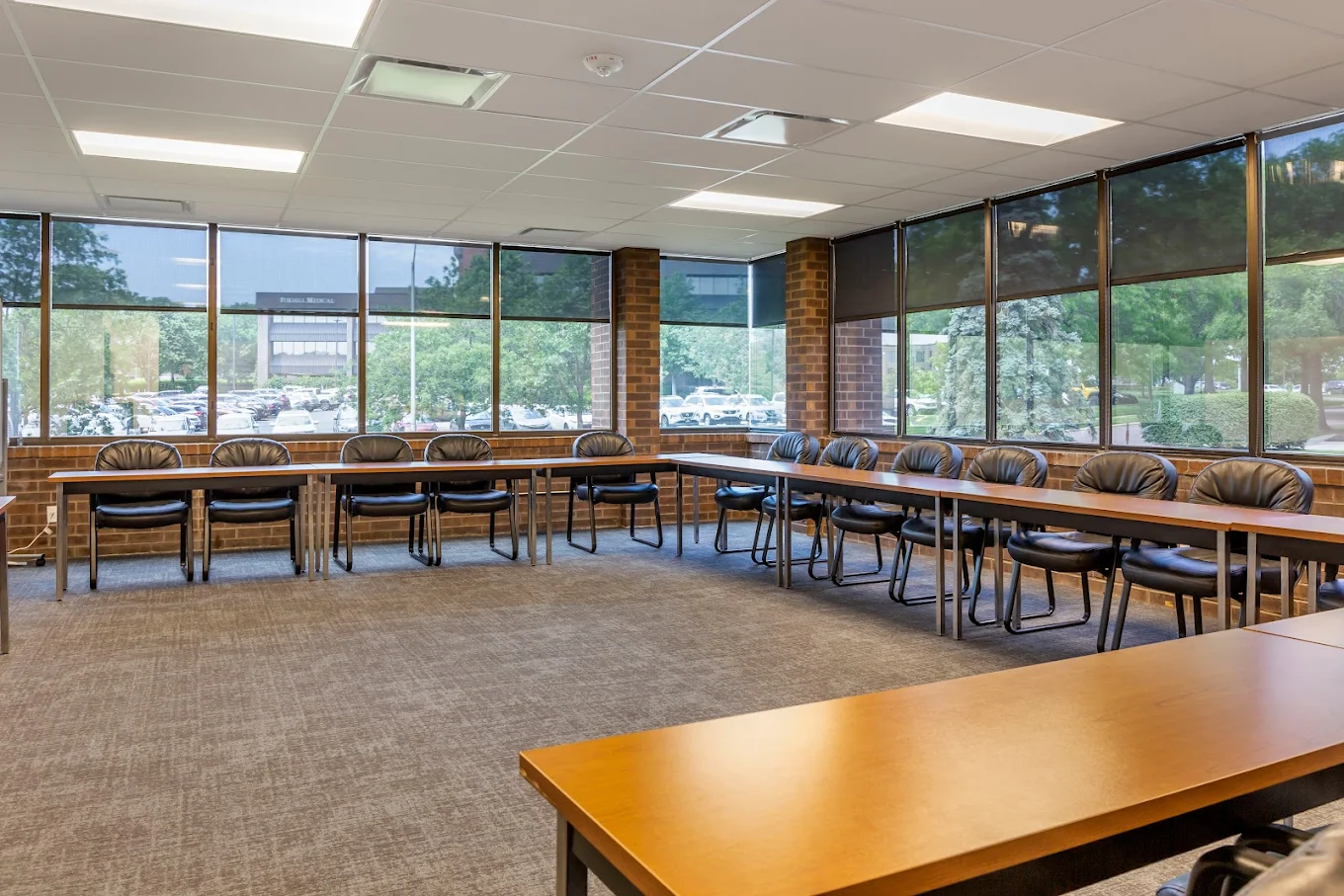 Large meeting room with tables, chairs, and window views