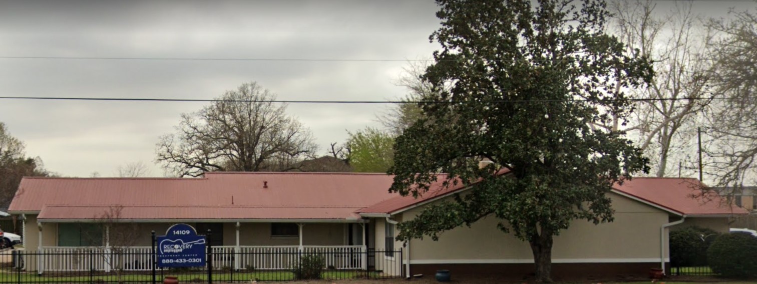 Wide view of rehab facility with a red roof and sign
