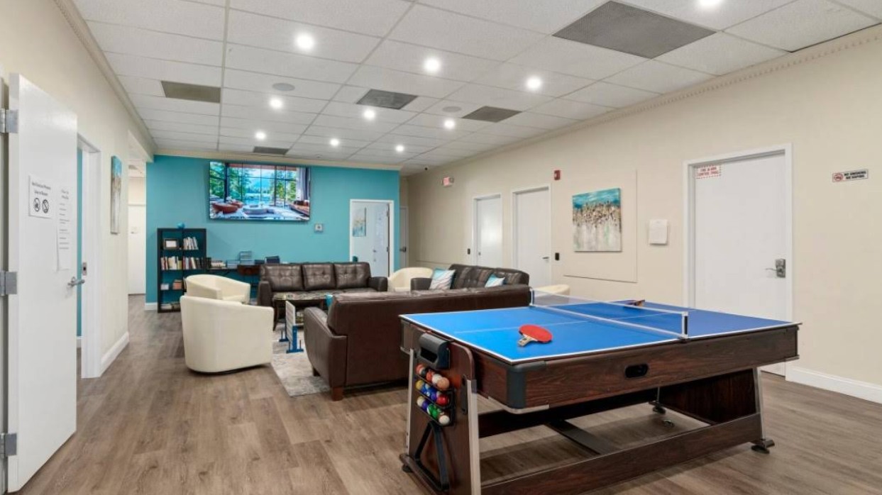 Lounge area with couches, TV, and ping pong table