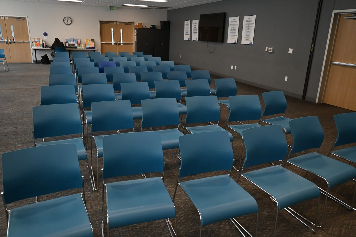 Large meeting room with rows of blue chairs