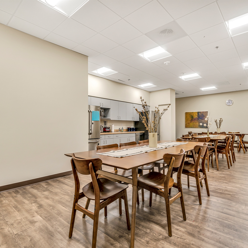 Dining area with tables and chairs and a kitchenette.