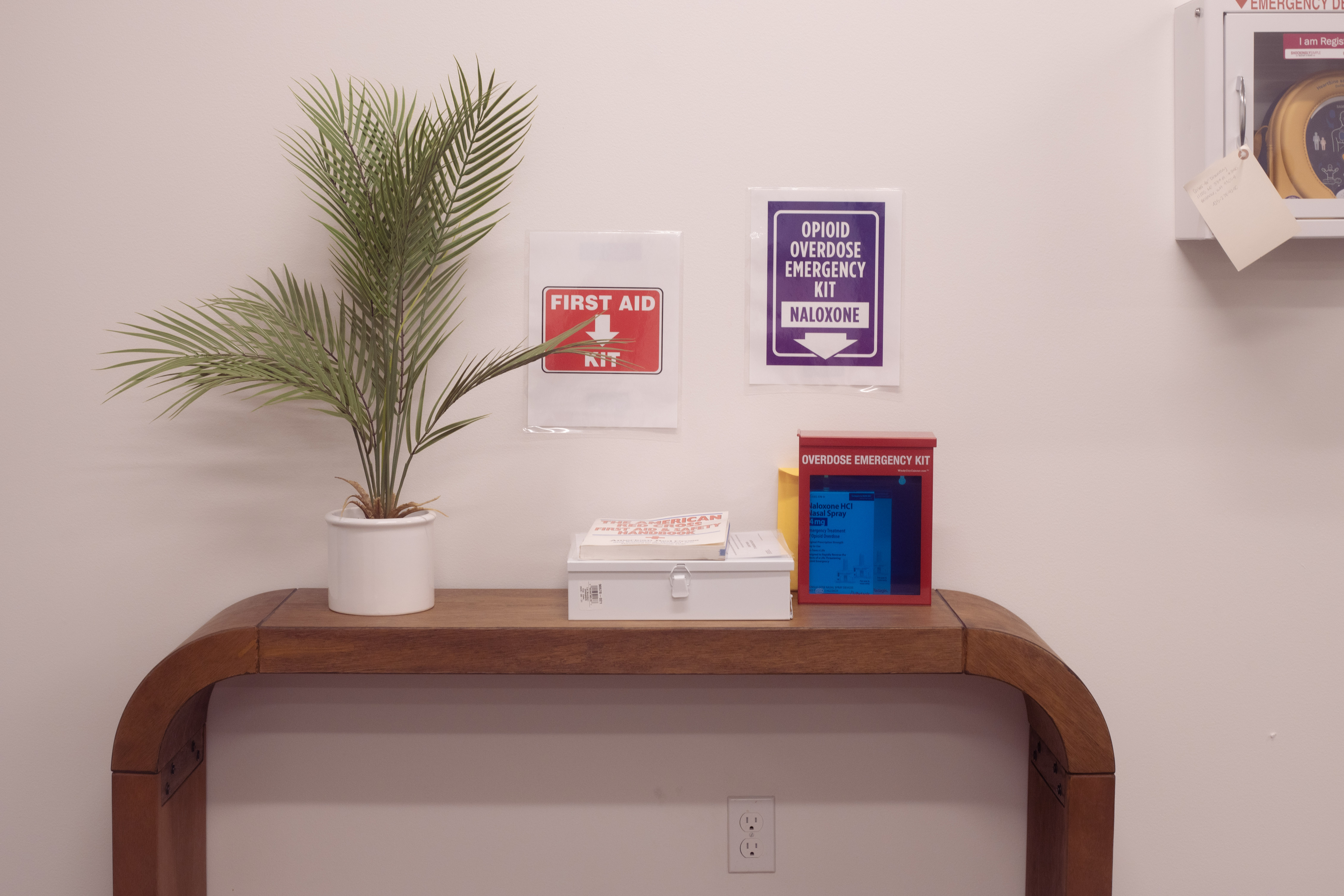First aid and overdose kits with signs on a wood table