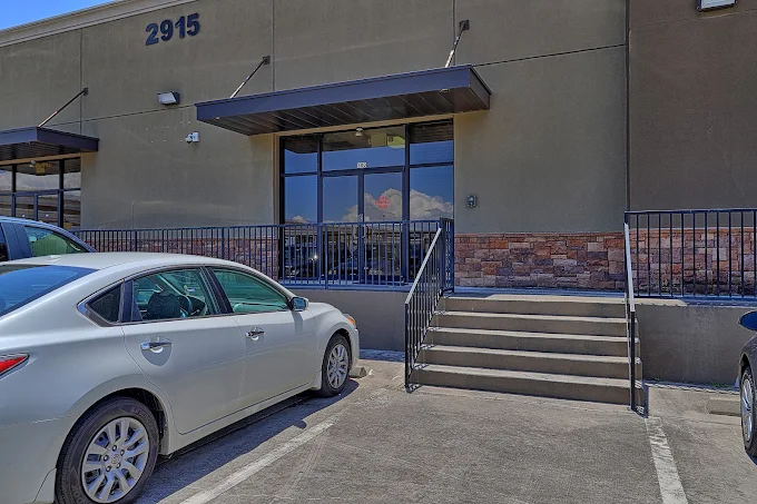 Exterior entrance with stairs and parked cars