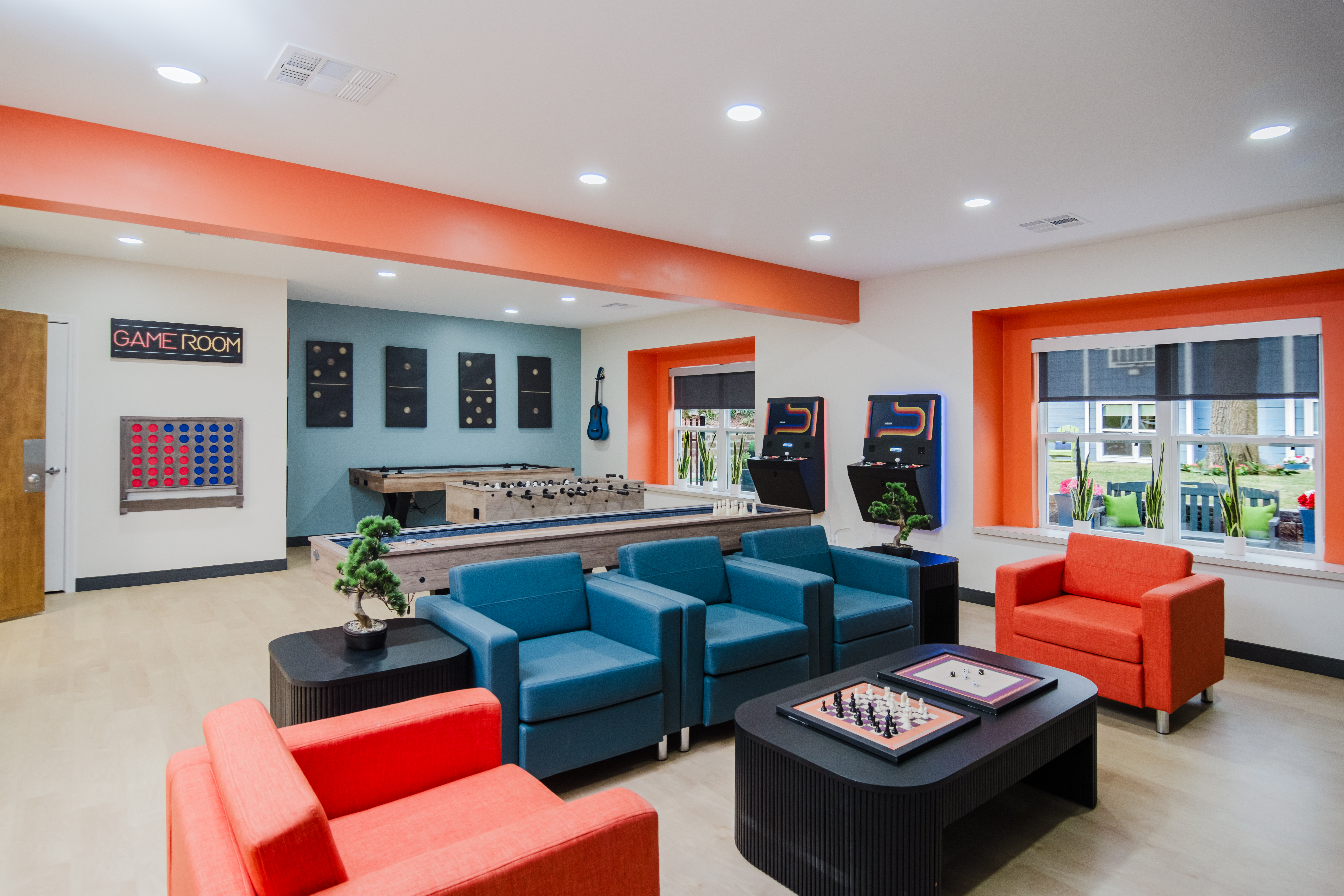 Game room with seating, arcade games, and tables.