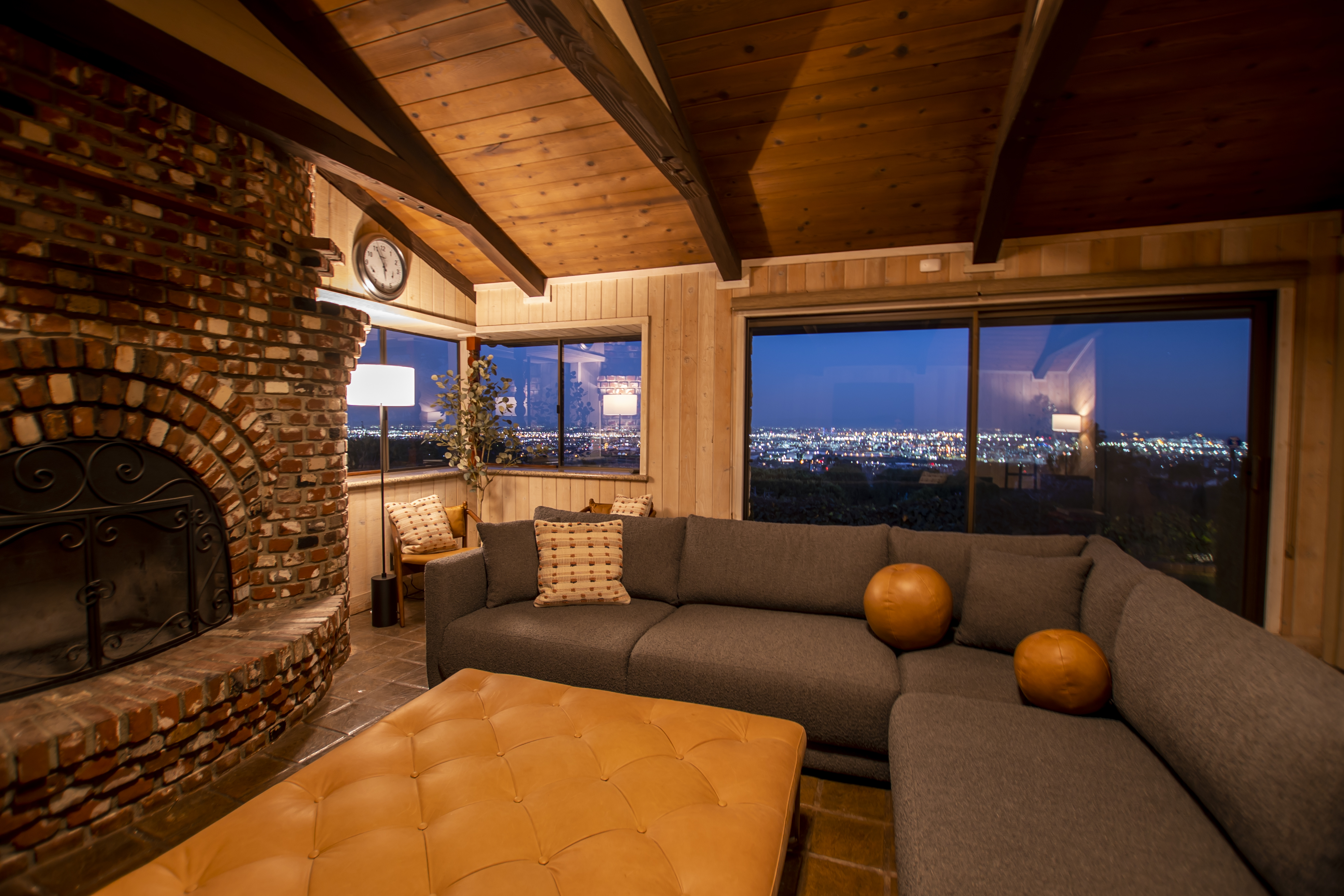 Cozy lounge with a brick fireplace, city lights visible at night