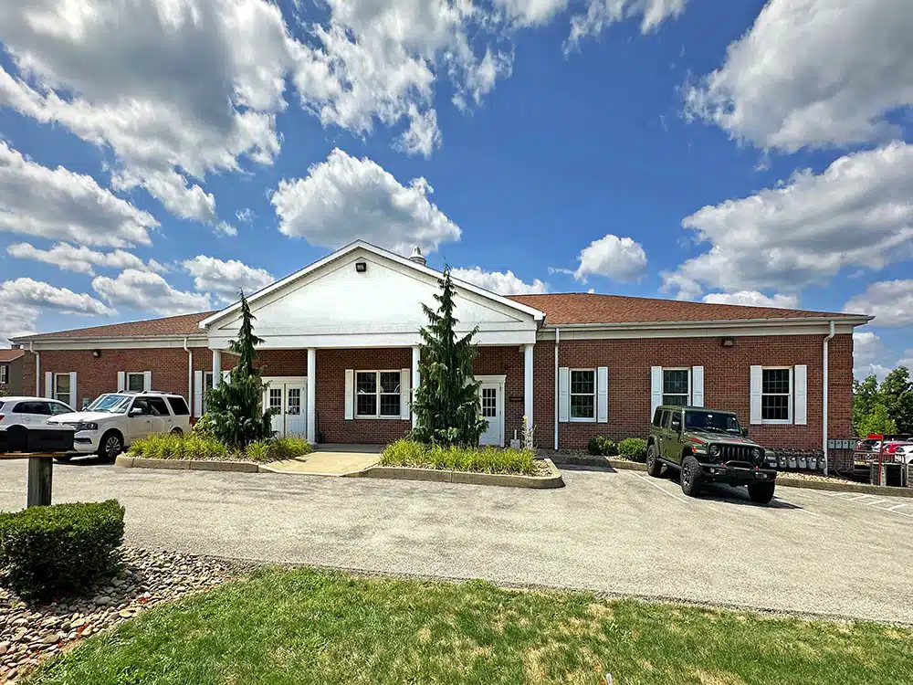 Brick clinic building with parking lot under blue sky