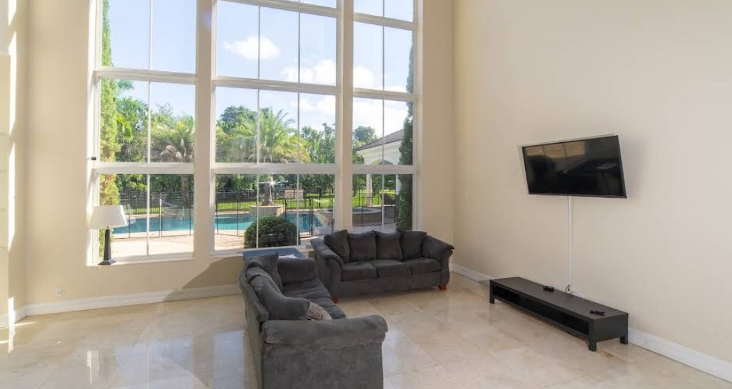 Spacious lounge with pool view and TV