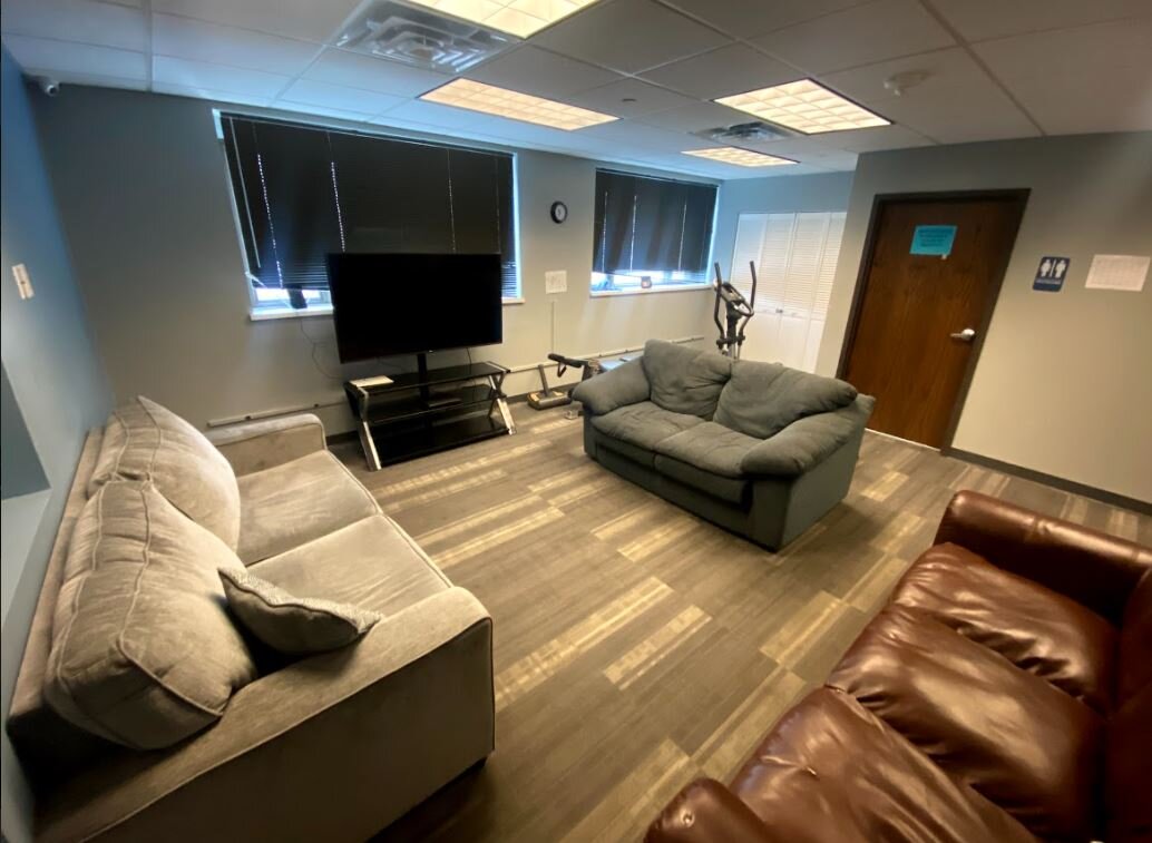 TV lounge room with couches and exercise bike