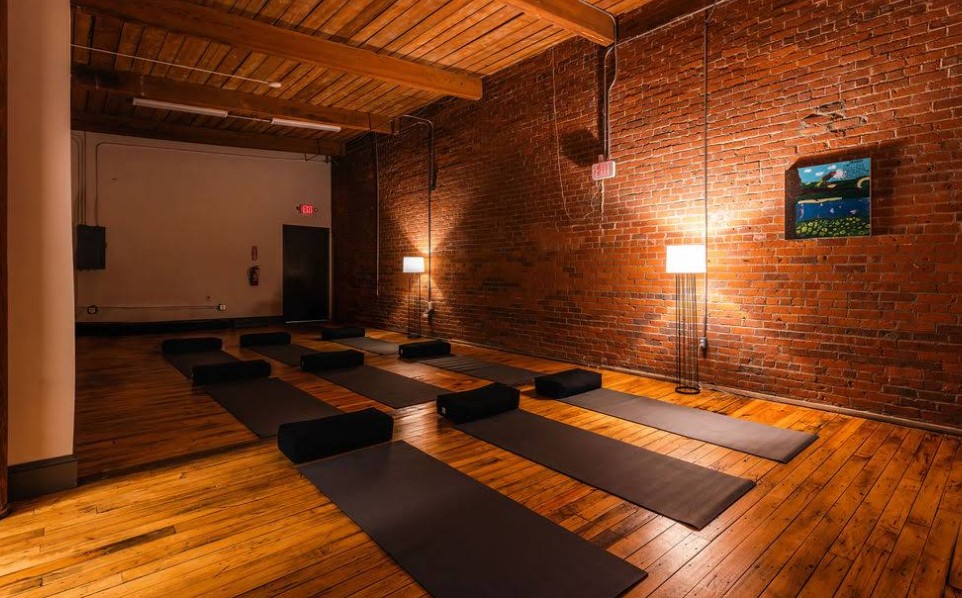 Yoga room with mats in a restored brick interior