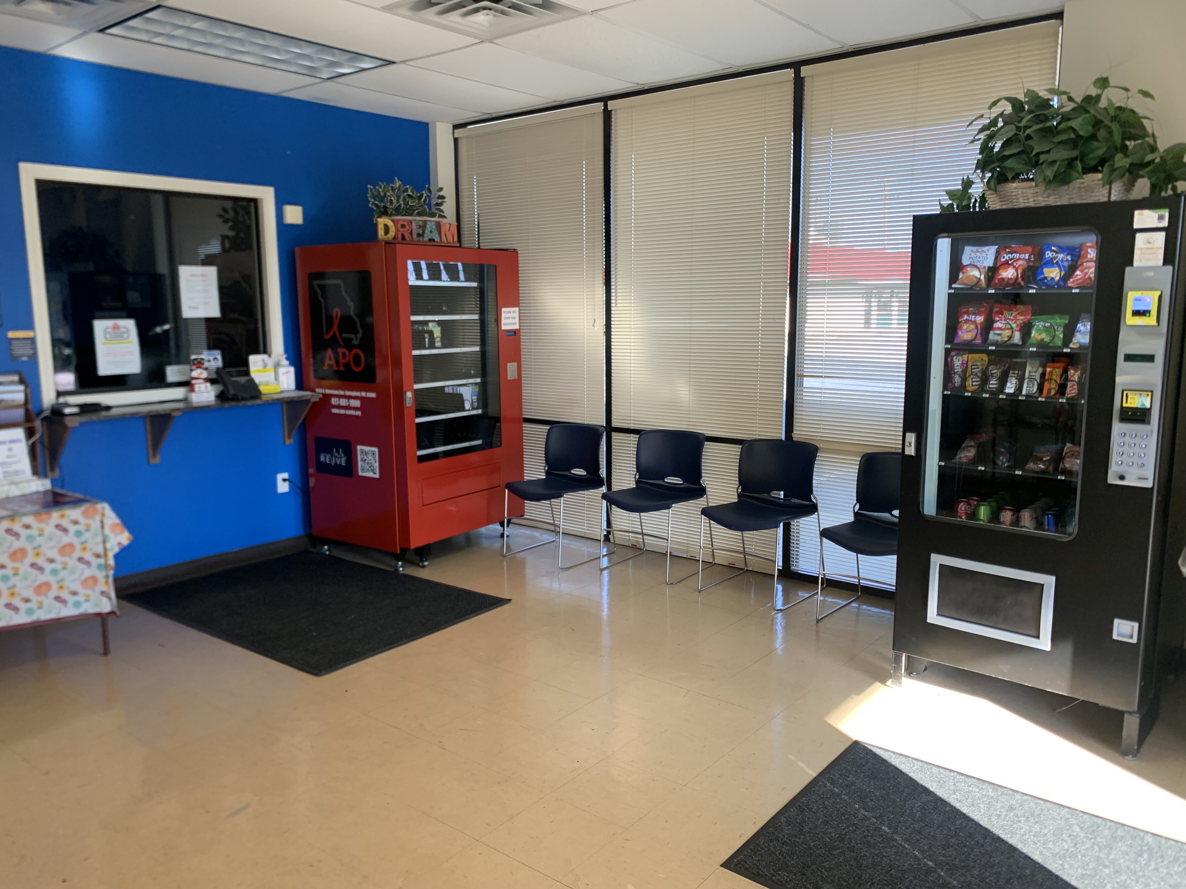 Lobby with waiting chairs, vending machine, and check-in window