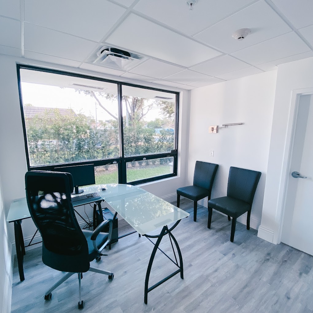 Modern office with a large window ,desk, and chairs.