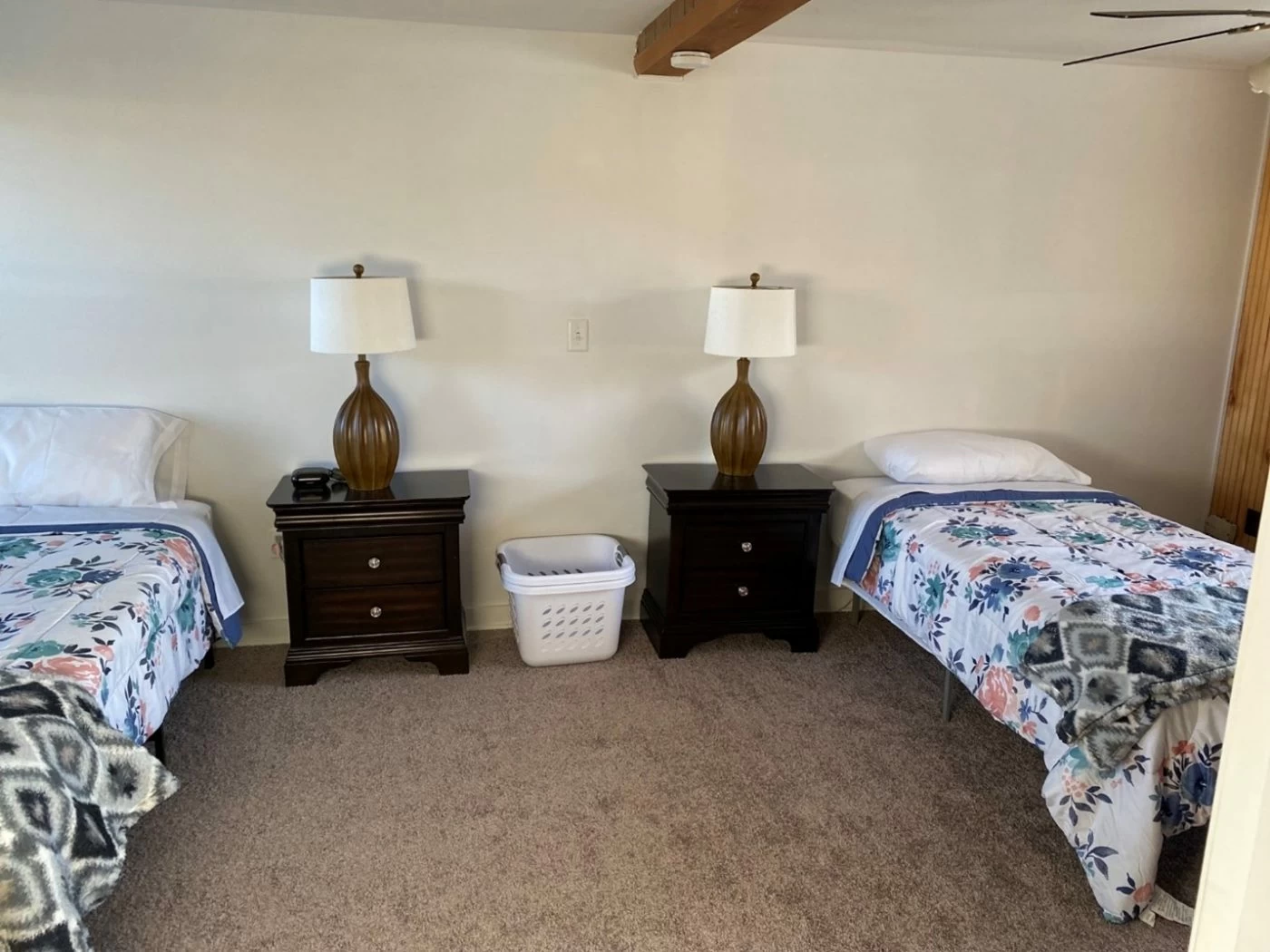 Twin beds with floral bedding and dark wood furniture