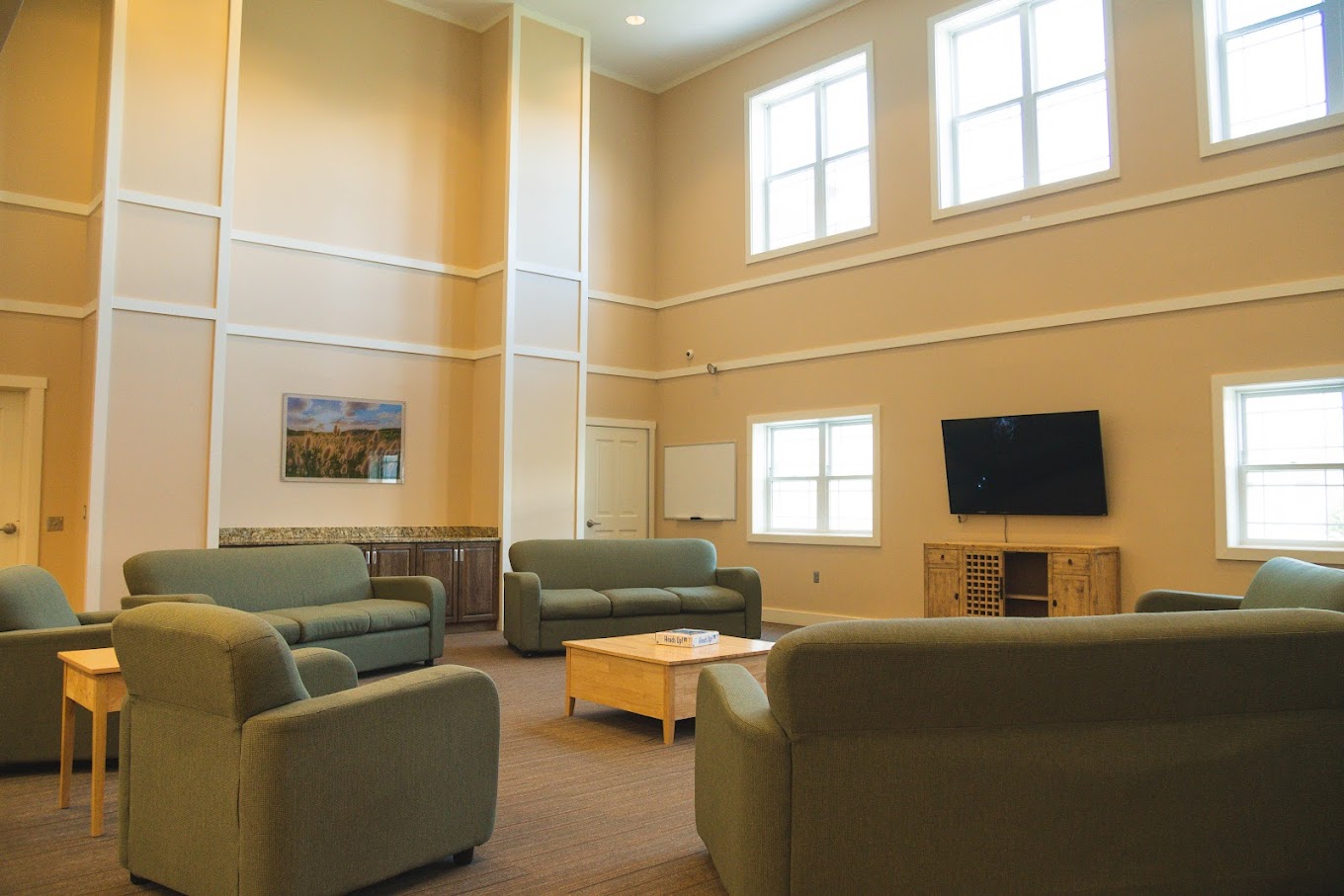 Comfortable lounge with sofas, TV, and natural light