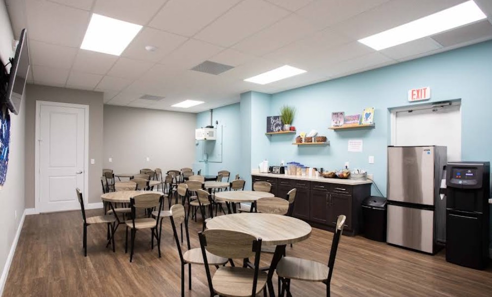 Community room with dining tables and refreshment area
