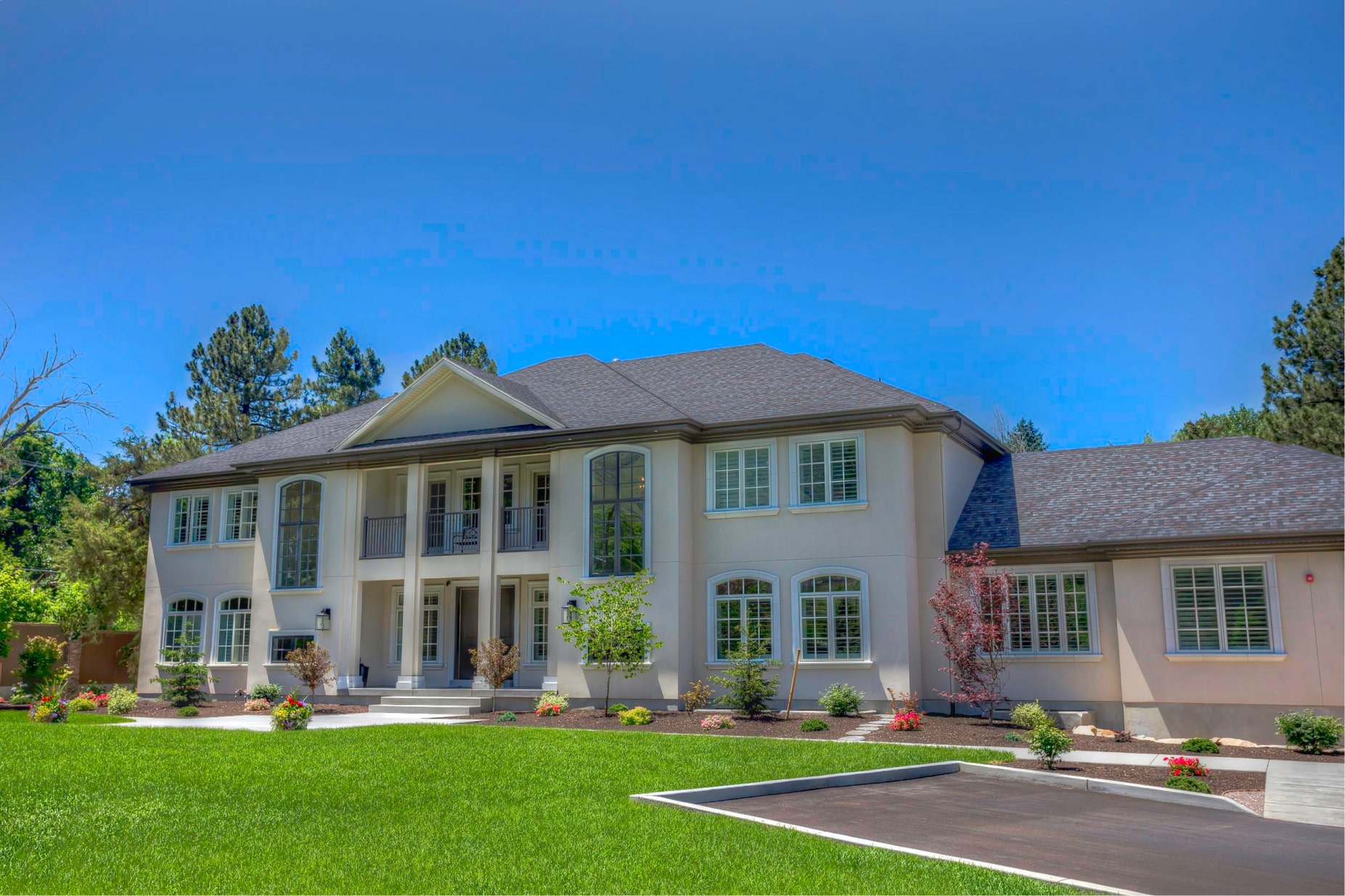 Two-story white house with large windows and green lawn