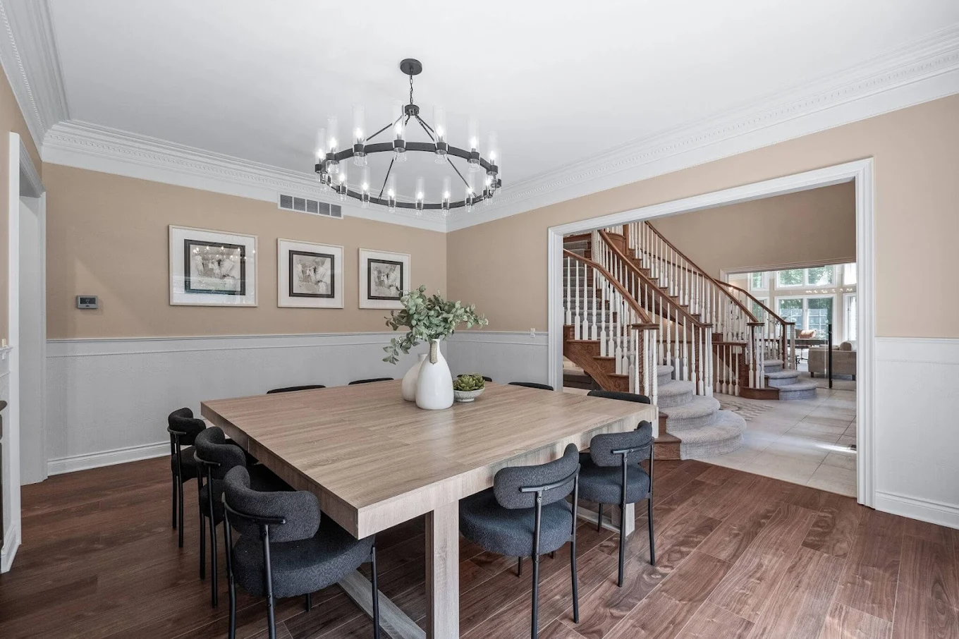 Dining table with 10 chairs near a grand staircase