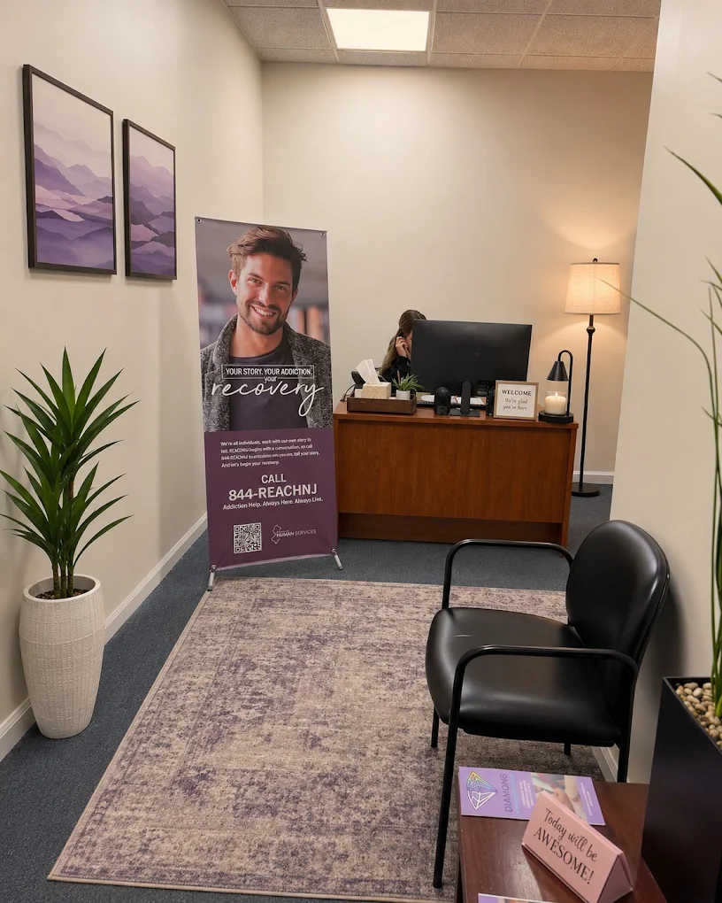 Reception area with chairs, front desk, rug, and potted plant