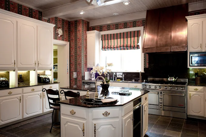 Spacious kitchen with white cabinets and island stove