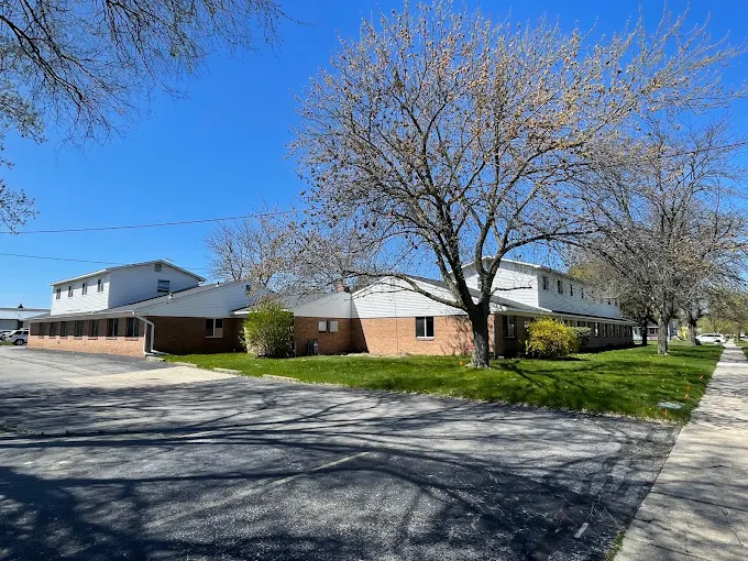 Brick and white building with trees and lawn