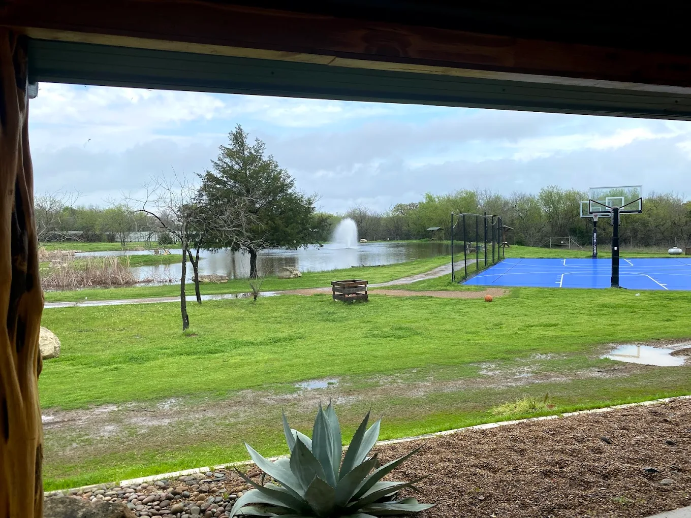 Blue basketball court by the lake and fountain in the courtyard