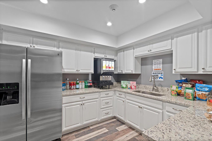 Kitchen with fridge, snacks, drinks, and white cabinets