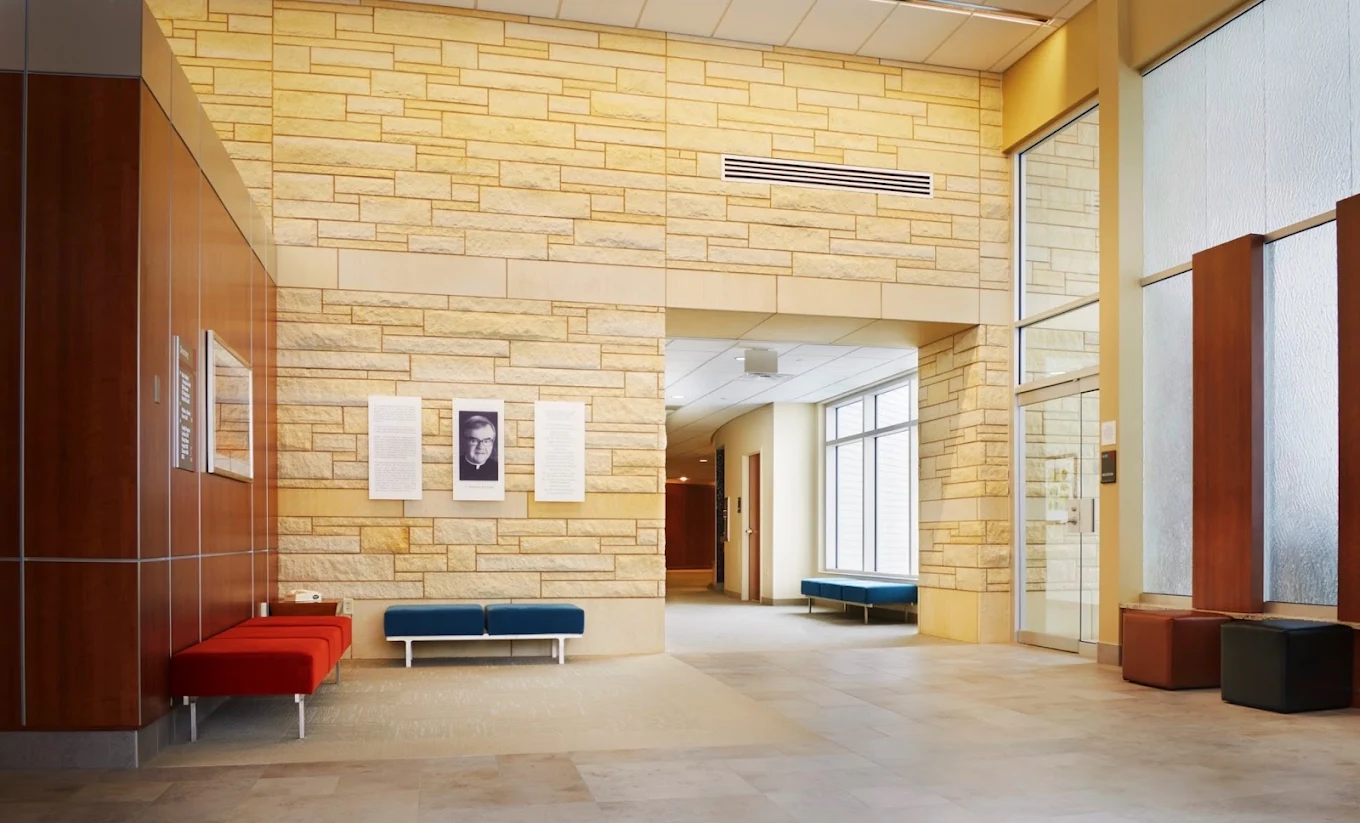 Spacious lobby with stone walls, modern seating, and large windows