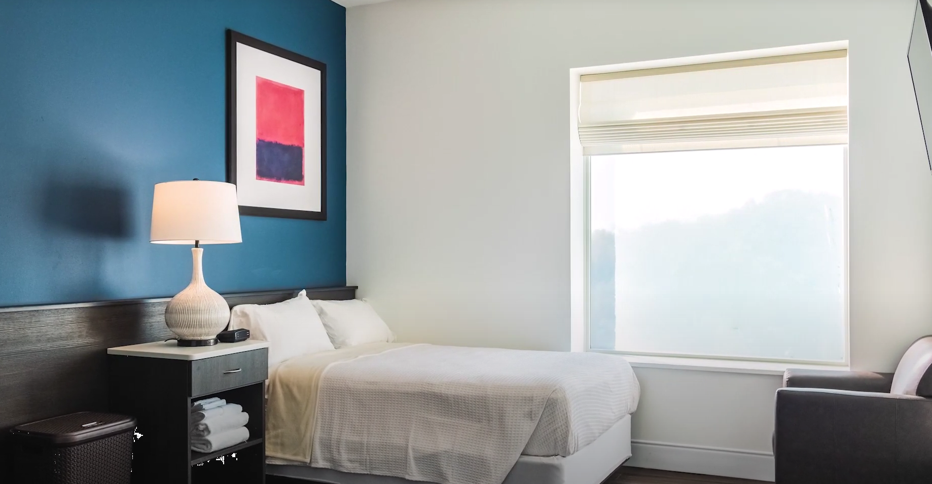 Clean private bedroom with bed, window, and nightstand