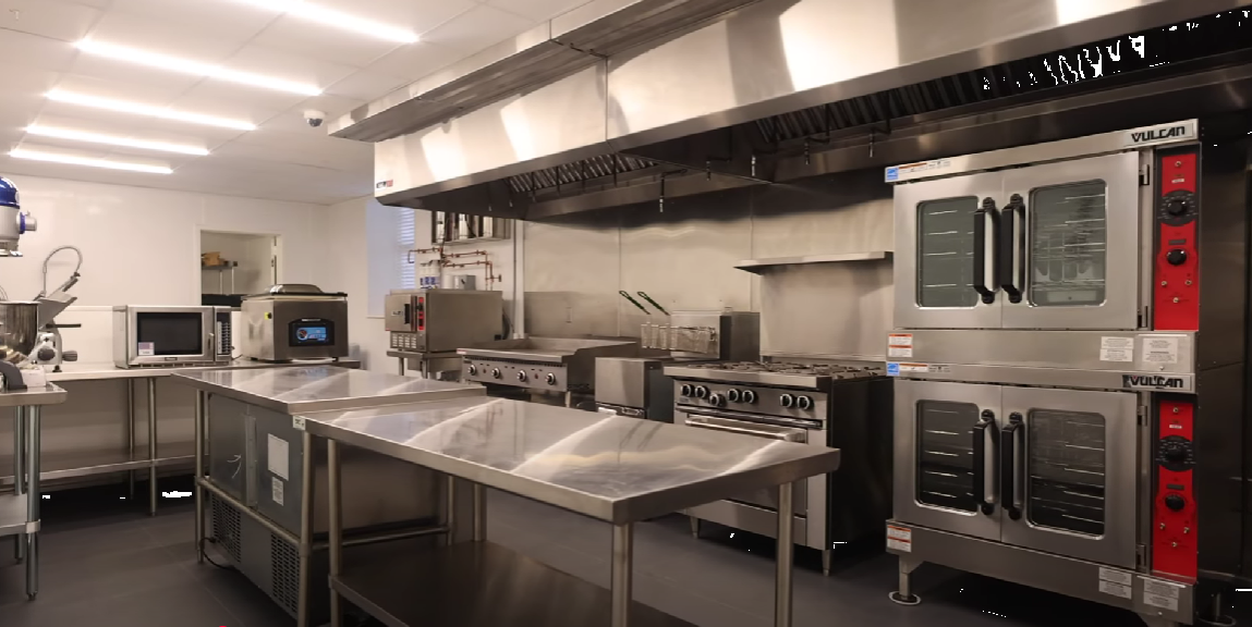 Commercial stainless steel kitchen with ovens and prep tables