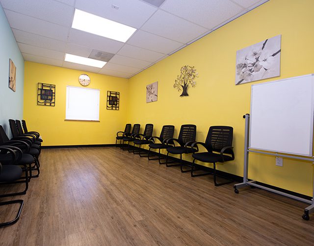 Yellow-walled therapy room with chairs arranged in a circle